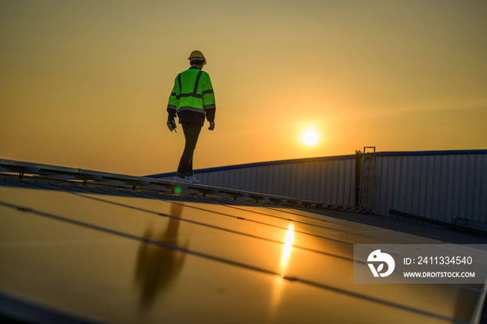 Silhouette of technician engineer checking and repairing solar panels on rooftop of solar cell farm power plant, Renewable energy source for electricity and power