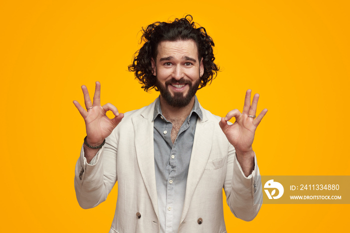 Positive ethnic man in suit showing approval okay gesture