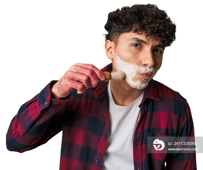 A young man preps for a smooth shave, applying foam with a brush for refreshing facial hair grooming, nourishing, and exfoliating care.