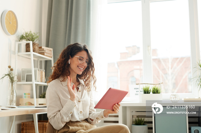 Modern young woman wearing stylish having video conference with her coworkers while staying at home