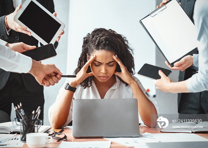 Overworked Afro Businesswoman Sitting Tired Of Multitasking In Modern Office