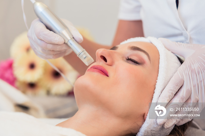 Close-up of the face of a woman relaxing in a modern beauty center during facial treatment with innovative technology for softening wrinkles and rejuvenation