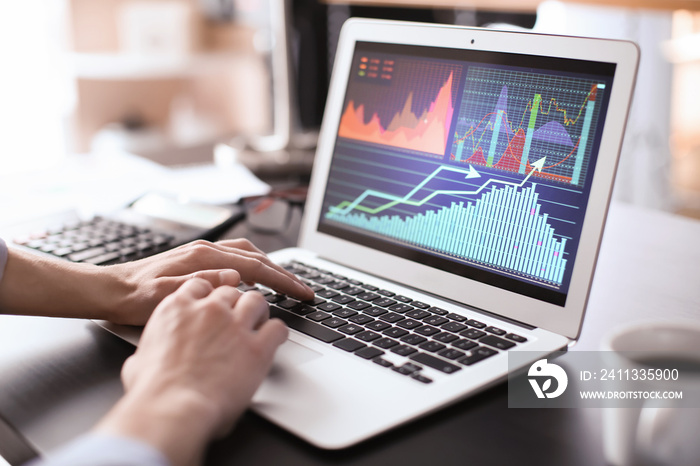 Man working at table in office, closeup. Financial trading concept