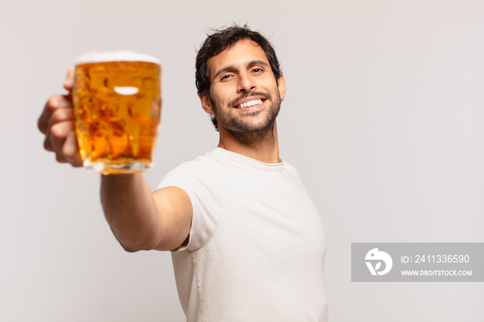 young handsome indian man happy expression and holding a beer