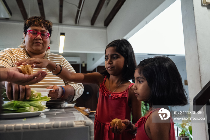 Kids helping their parent cook a healthy meal for the family dinner at home