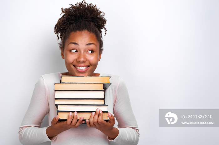 Portrait of happy nerd young girl holding books over white background. Back to school