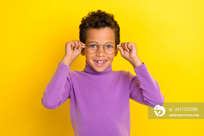 Portrait of cheerful smart schoolchild hands touch glasses toothy smile isolated on yellow color background