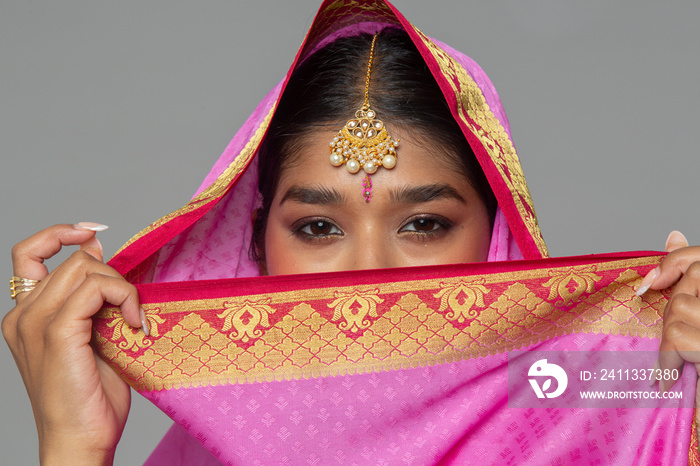 Close-up of woman wearing sari and gold jewelry