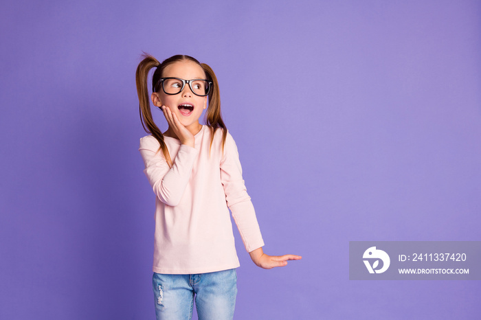 Photo of dreamy amazed pretty child hold hand cheek look copyspace wear glasses isolated on violet color background