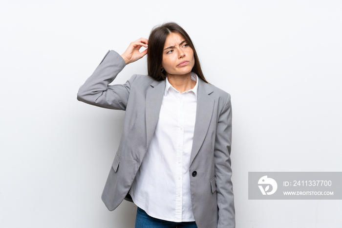 Young business woman over isolated white background having doubts while scratching head