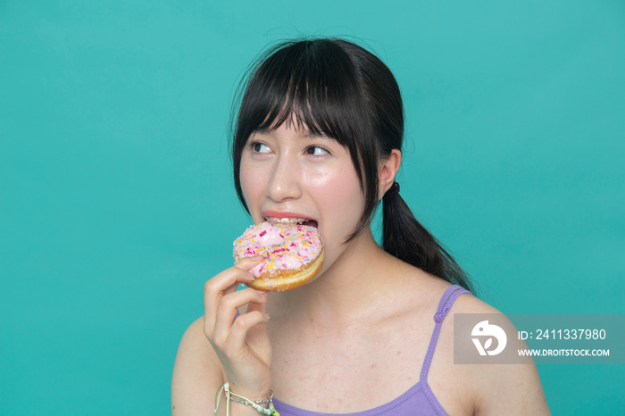 Studio portrait of girl eating donut