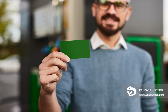 Customer showing green loyalty card at gas station