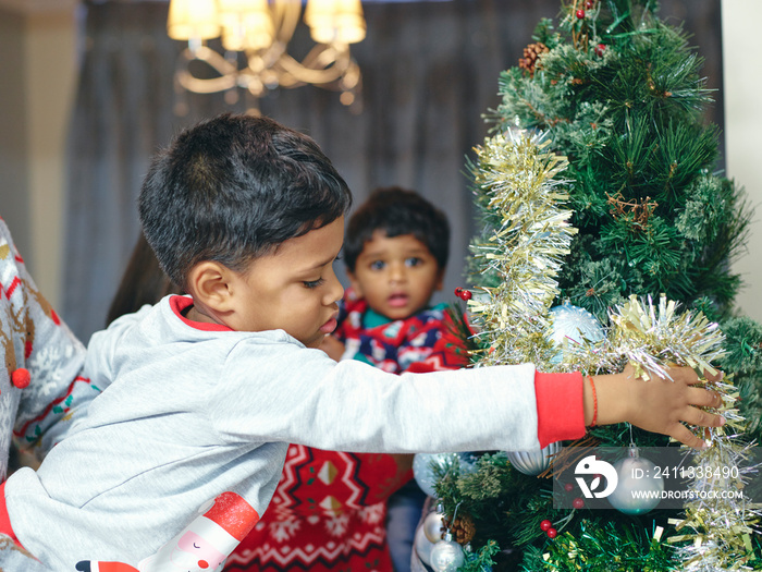 Parents and sons decorating Christmas tree