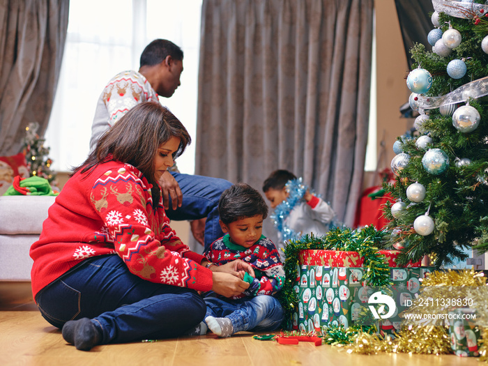 Parents and sons playing with Christmas decorations