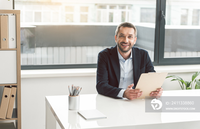 Happy businessman locating at desk