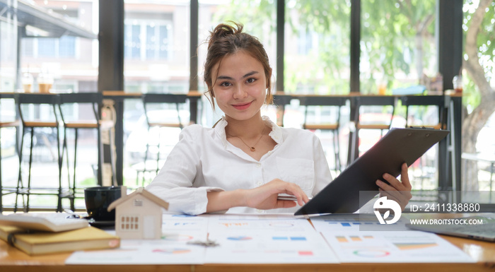 Confident young female financial advisor preparing contract document for her client