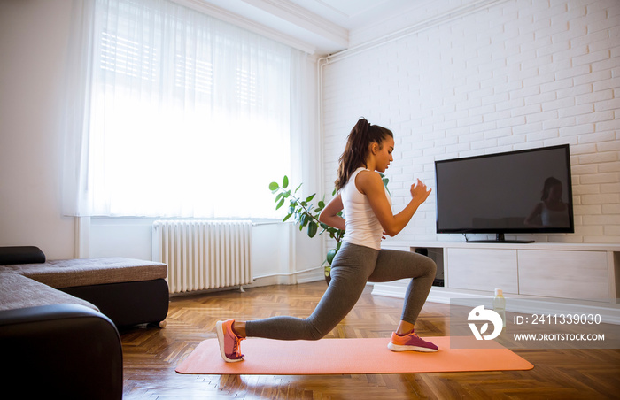 Young attractive woman practicing exercises at home