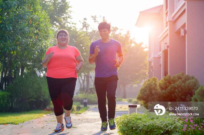 happy and enjoy morning jogging of plump fat woman and coach or trainer running together exercise