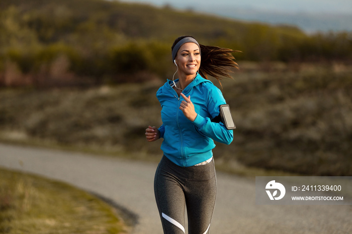 Young happy athletic woman jogging in nature.