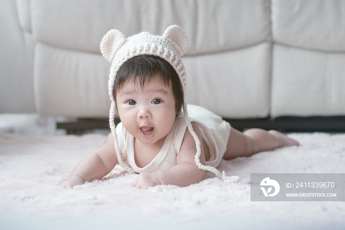 Closeup asian baby girl lie on carpet  in cute motion