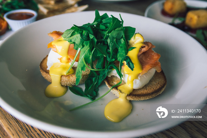 Eggs benedict restaurant dish served with smoked salmon and hollandaise sauce. Eggs royale dish.