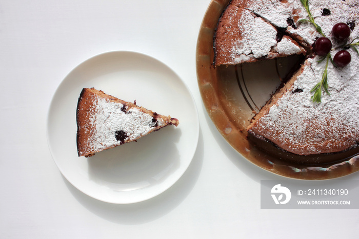 Pice of freshly baked cherry cake on white table background. Overhead view of homemade berry pie.