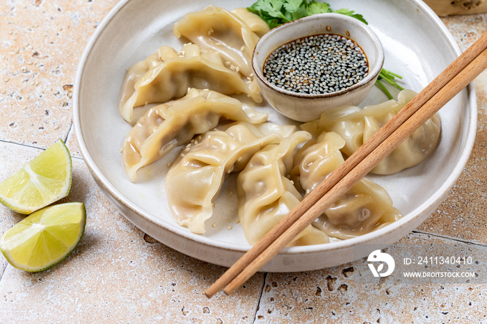 Dumplings gyoza jiaozi steamed  on a white plate with soy sauce. Takeout  food