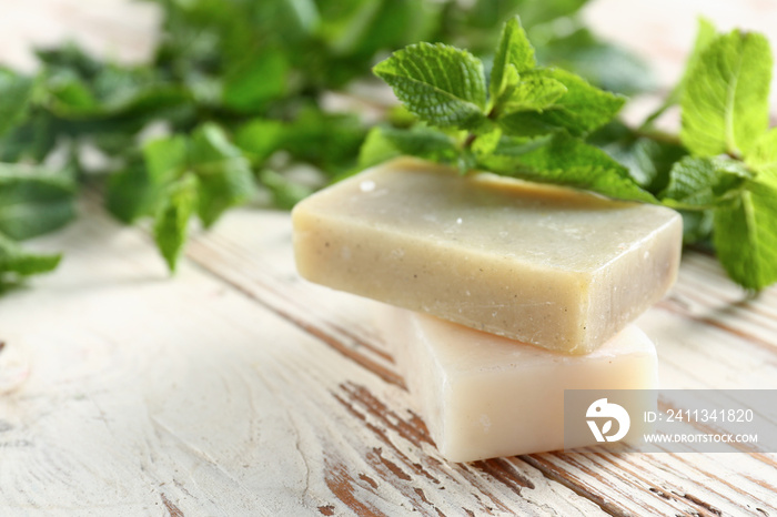 Fresh mint and soap on wooden background