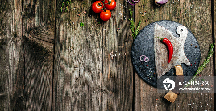 Composition with metal meat cleaver and ingredients for cooking on wooden background. Long banner format. top view