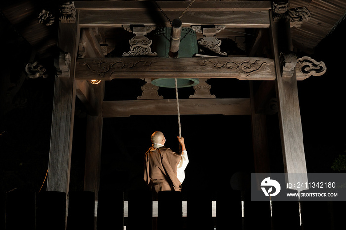 除夜の鐘をつく僧侶