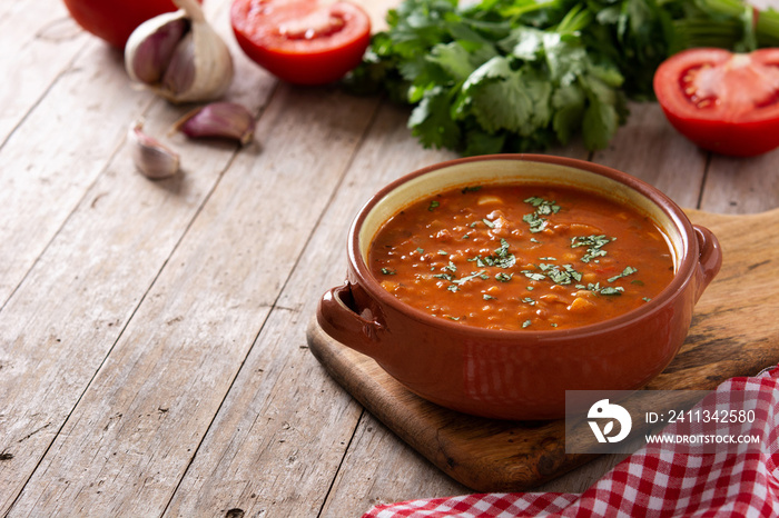 Red lentil soup in bowl on wooden table. Copy space