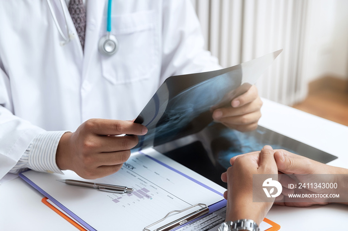 Medical and health care  concept. Doctor explaining x-ray results to patient while sitting at the table in office.