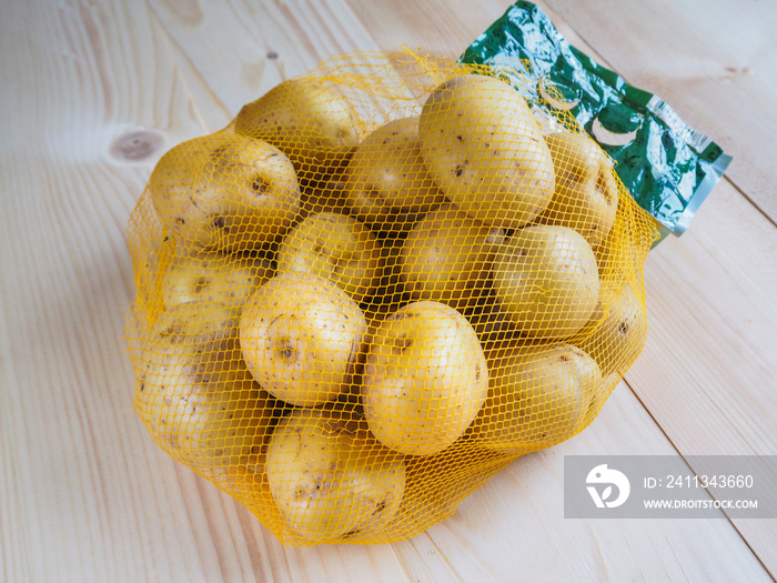 Raw potatoes in a grid on a light wooden background.