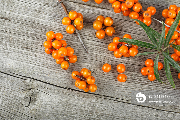 Sea buckthorn berries on wooden background, top view.