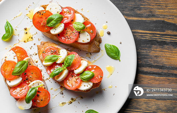 bruschetta caprese. fresh basil leaves, ripe aromatic tomatoes and Italian mozzarella on bruschetta, drizzled with olive oil and sprinkled with pepper and herbs.