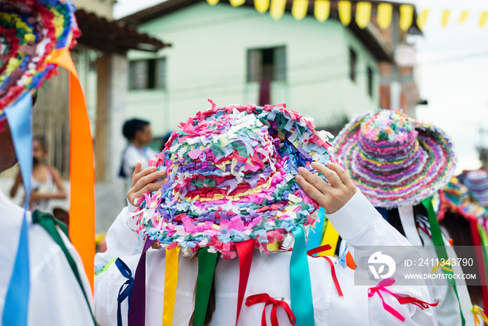 Men, women and children, members of the cultural group Chegança dos Marujos, dance and sing in costumes during a performance at the streets of Saubara, Bahia.