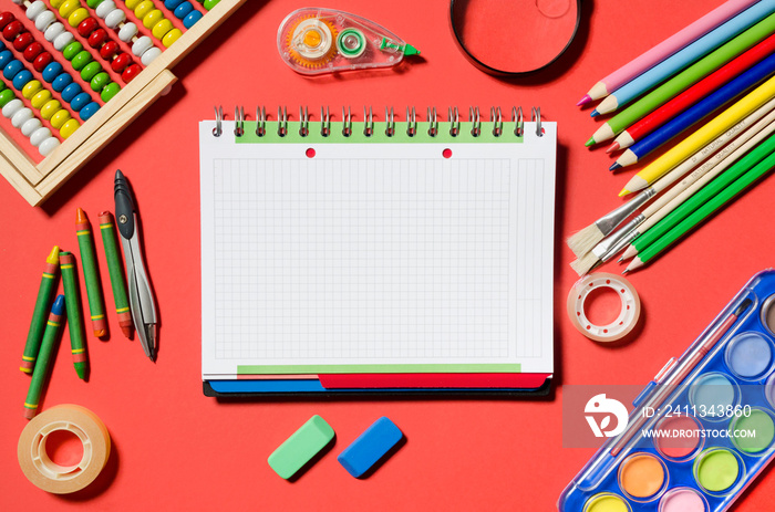 Notepad and school supplies, stationery, red background.