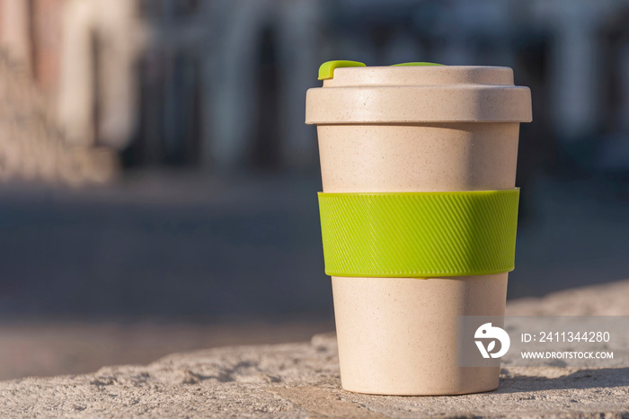 Eco cup on a background of buildings. The concept of ecology and lack of garbage