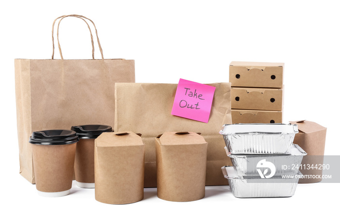 Paper bags with sticker TAKE OUT, containers for food and cups on white background