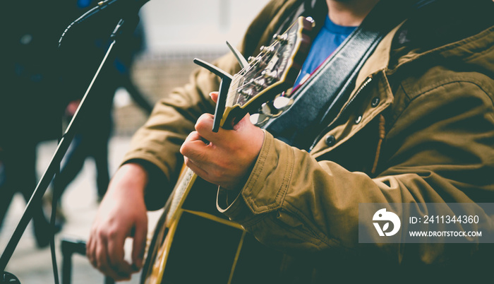 Street musician playing guitar. London lifestyle