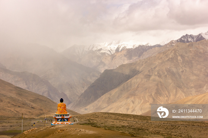 A colourful Buddha statue facing Himalayan mountains in the village of Langza in the Spiti Valley