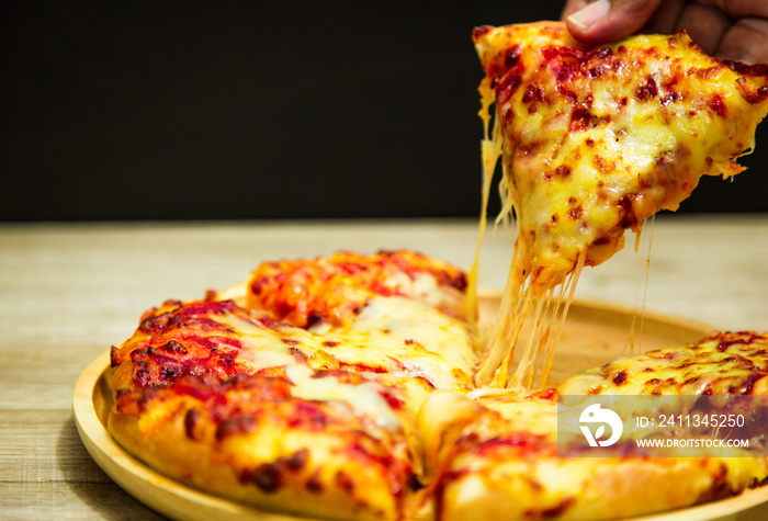 Hot pizza slice with melting cheese on a table in restaurant pizza Italian food.