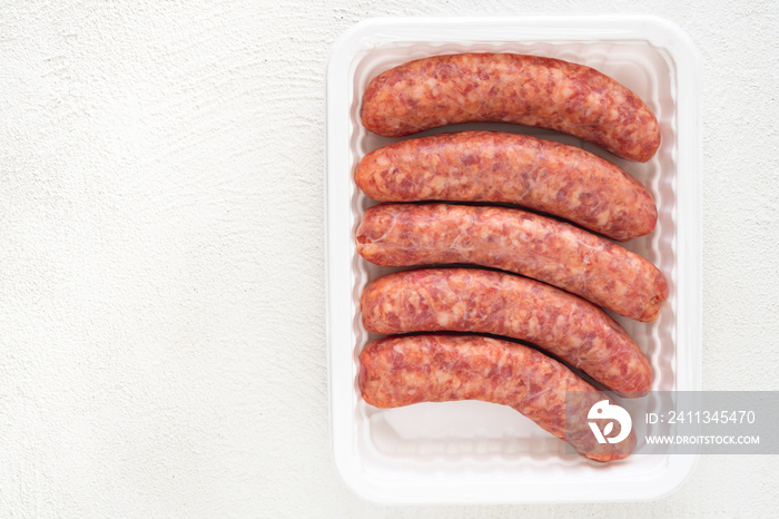 Fresh Raw Sausages in White Plastic Container Top View Close Up, Copy Space