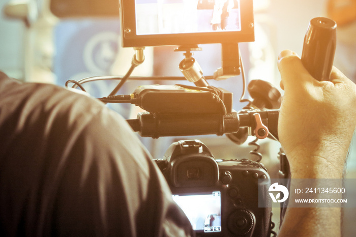 Cameraman with his video camera shooting, Hands Adjusting Camera,film production crew,behind the scenes background.