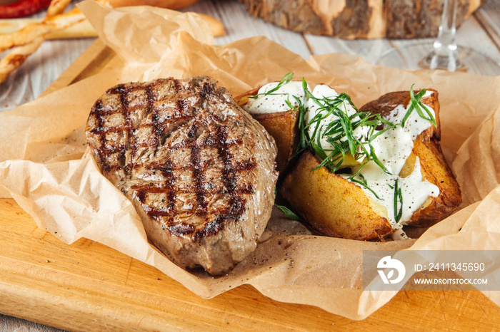 Beef steak with baked potatoes with sour cream