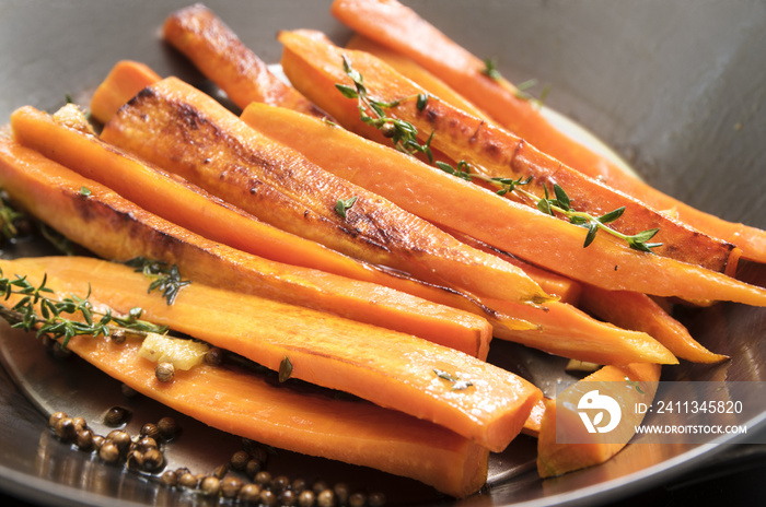 roasted carrots with thyme, coriander seed and honey in a wok pan,  recipe for root vegetables