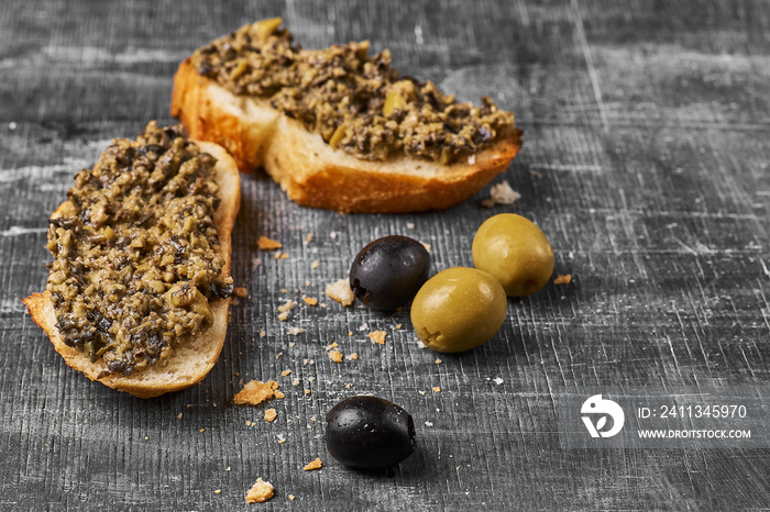 Bruschetta with green olives, anchovies,capers, selective focus, low angle view.