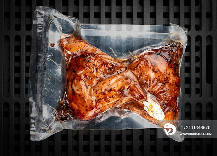 Vacuum-packed grilled meat, on a dark background, chicken thighs. Ready to eat.