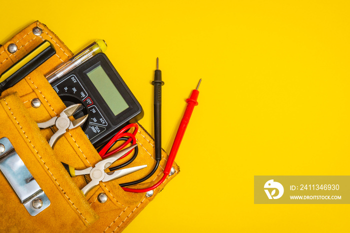 Set of tools in suede bag on yellow background prepared by the master electrician before repair or construction