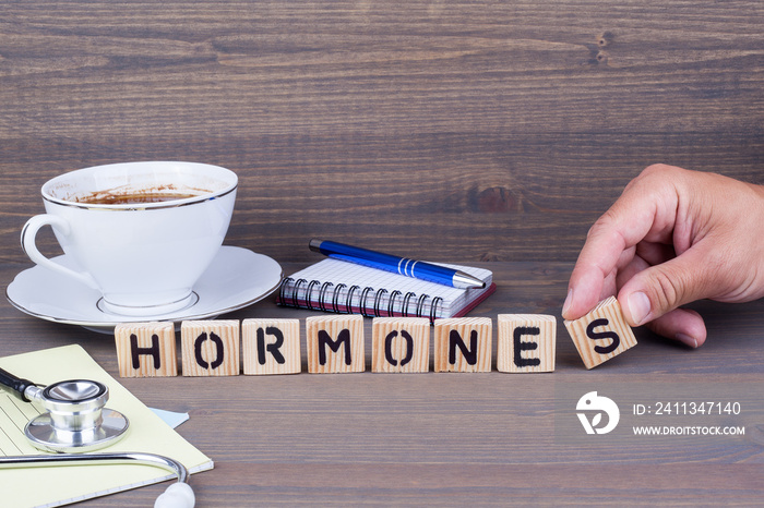 hormones. Wooden letters on dark background. Office desk